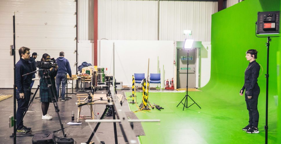 Coworking space St Louis with professional studio setup, green screen background, cameras, lighting, and chairs for interviews or content creation.