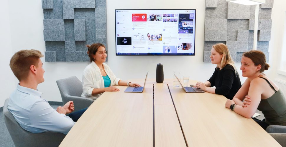 Corporate event venue with people attending a conference in St. Louis, featuring professional A/V setup and presentation screens.